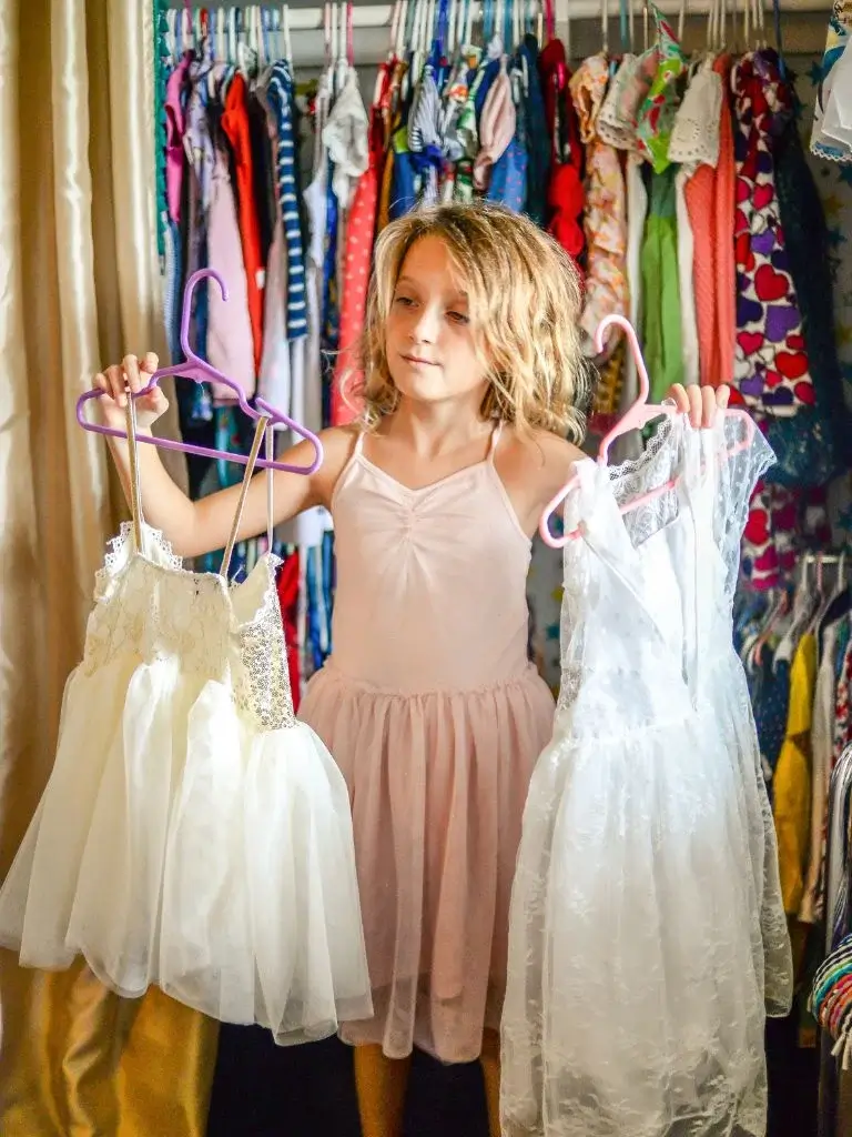 A girl deciding on which dress to wear
