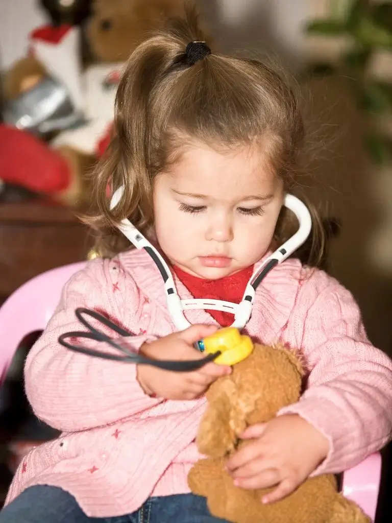 a toddler with a fake stethoscope toy