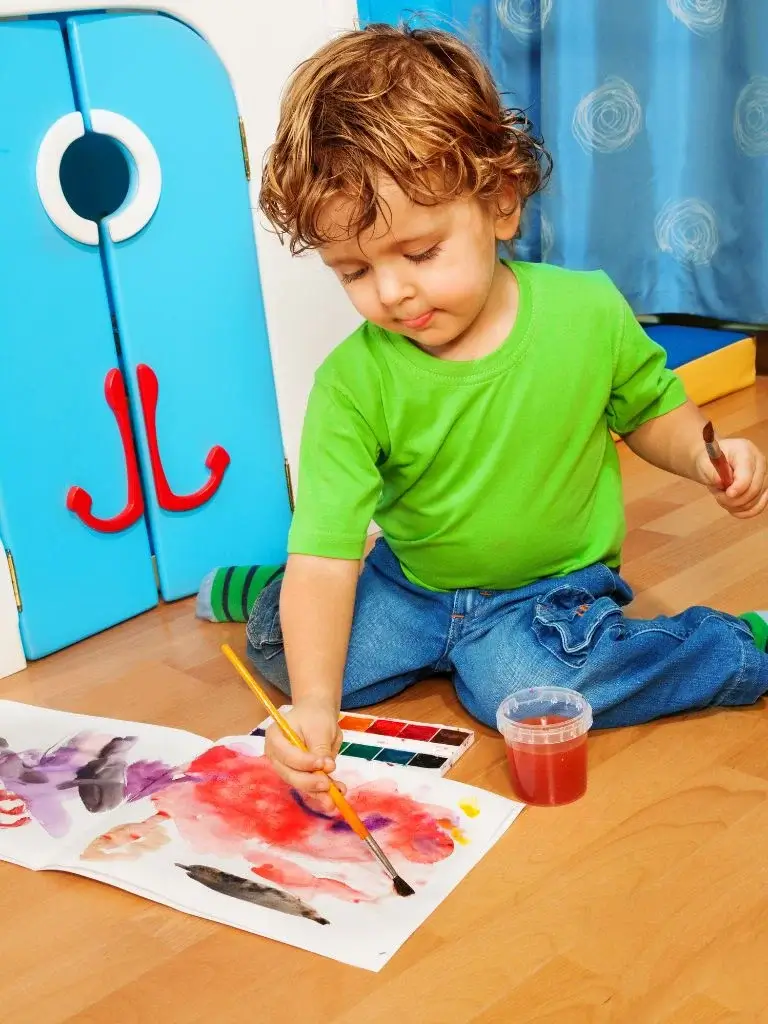 a toddler painting on paper