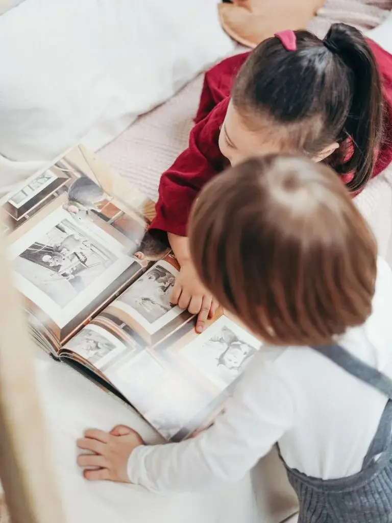 a top shot of 2 toddlers reading book together
