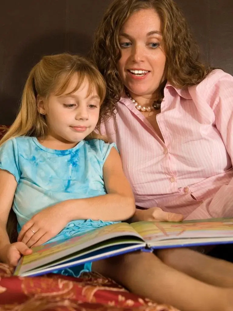 a little girl and mom reading a storybook together