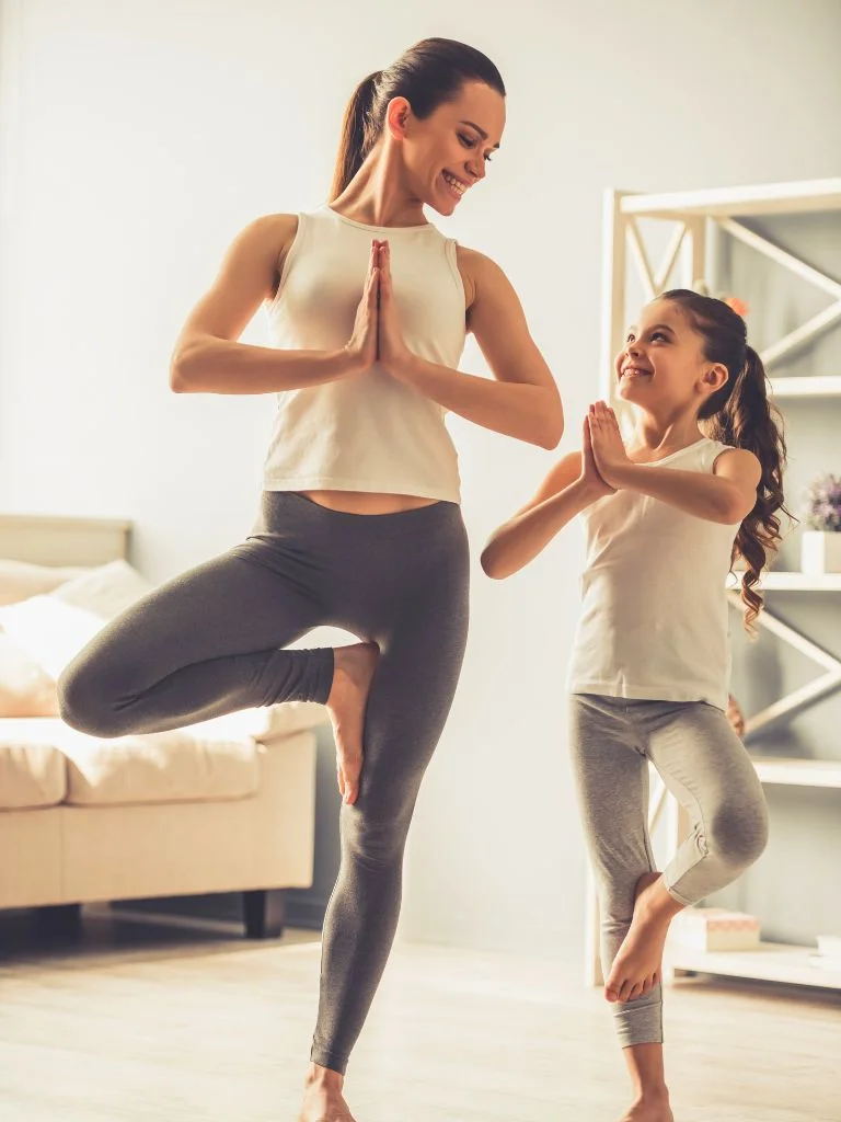 A mom and a daughter doing yoga poses together