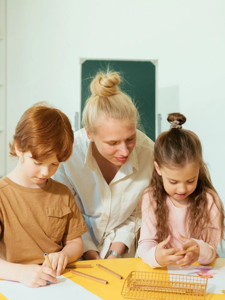 a picture of 2 school going kids with a teacher