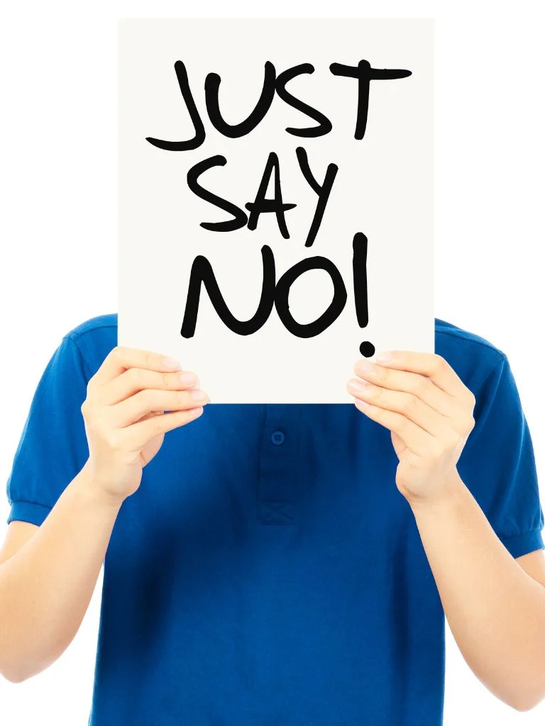 a man standing with his face covered with a paper that reads "just say no"