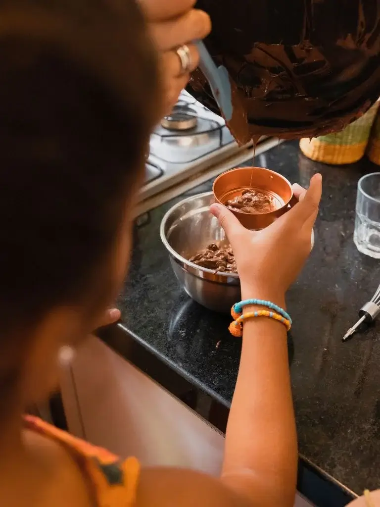 a toddler making chocolate in kitchen