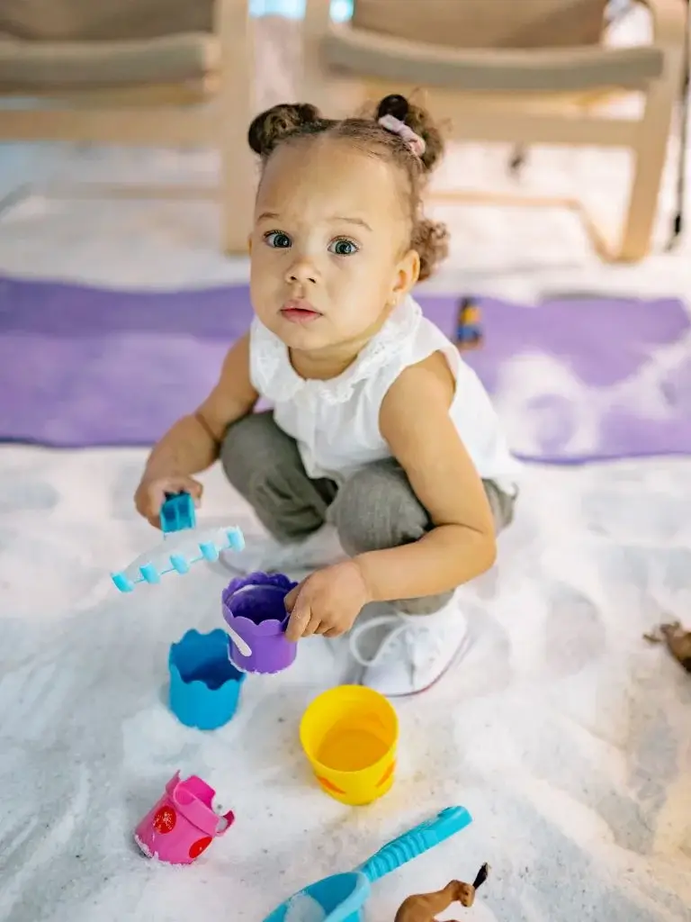 a toddler playing with colorful plastic toys