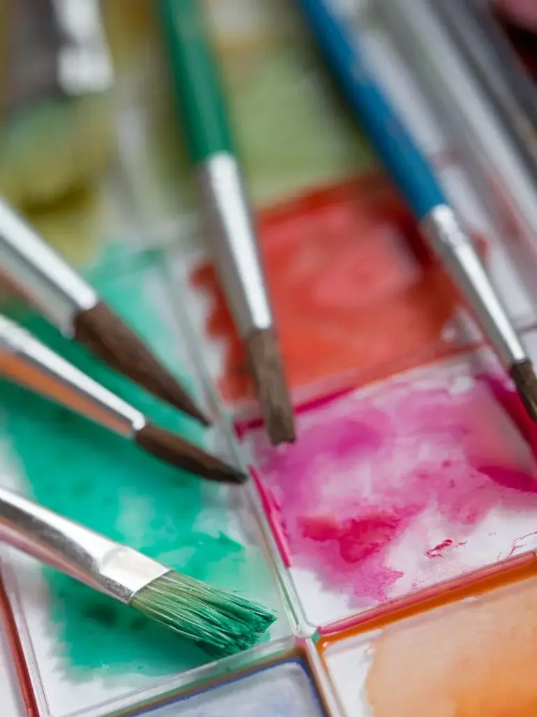 pain brushes place on a colorful painted paper 